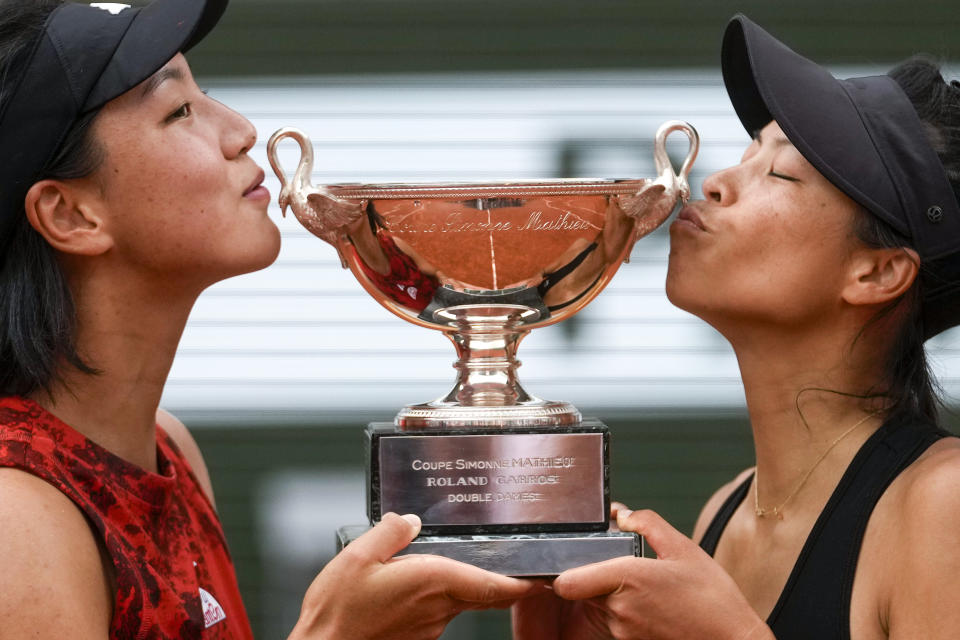 China's Wang Xinyu, left, and Hsieh Su-Wei of Taiwan kiss the trophy as they celebrate winning the women's doubles final match of the French Open tennis tournament against Canada's Leylah Fernandez and Taylor Townsend of the U.S. at the Roland Garros stadium in Paris, Sunday, June 11, 2023. (AP Photo/Thibault Camus)