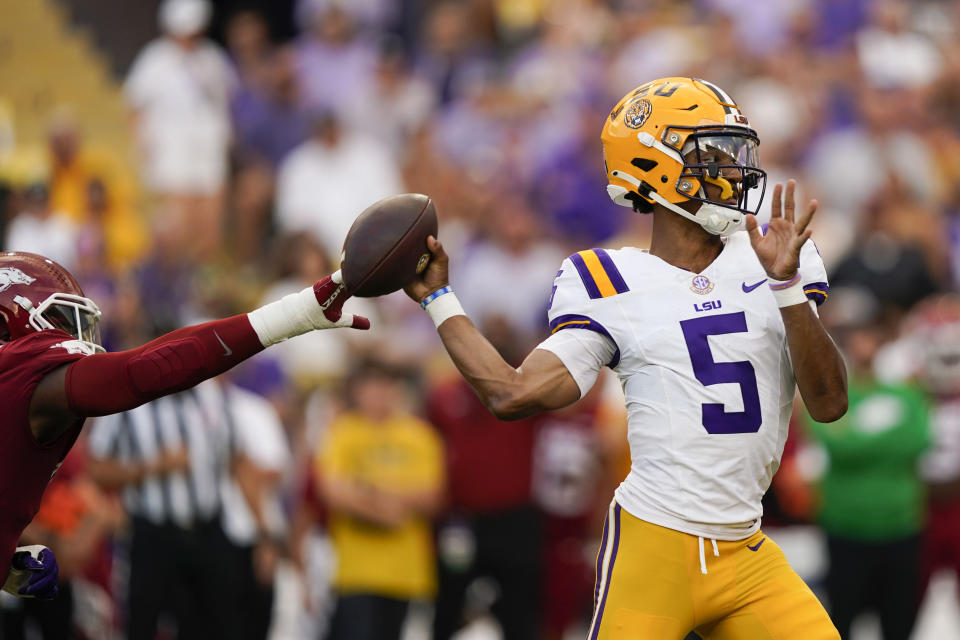 LSU quarterback Jayden Daniels (5) passes under pressure in the first half of an NCAA college football game against Arkansas in Baton Rouge, La., Saturday, Sept. 23, 2023. (AP Photo/Gerald Herbert)