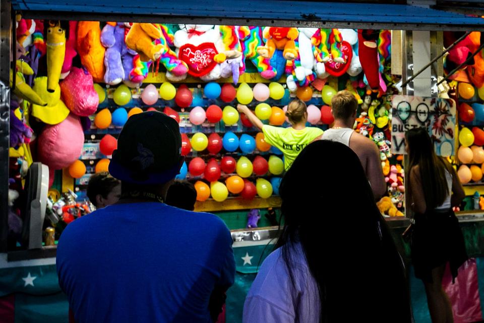 People line up in front of a carnival game during 4thFest, Saturday, July 3, 2021, at S.T. Morrison Park in Coralville, Iowa.