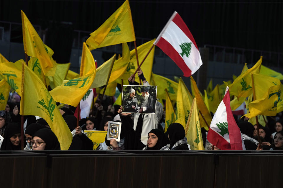 A Hezbollah supporter holds a picture of Iranian Supreme Leader Ayatollah Ali Khamenei, right, and slain Iran's Quds force General Qassem Soleimani, who was killed in a U.S. drone strike in Baghdad, left, during a rally marking Hezbollah Martyr's Day, Lebanon, Friday, Nov. 11, 2022. Hezbollah's chief Hassan Nasrallah said his group wants a new Lebanese president that will not "betray" the Iran-backed faction in the future adding that the United States is doing all it can strangle the group. (AP Photo/Bilal Hussein)