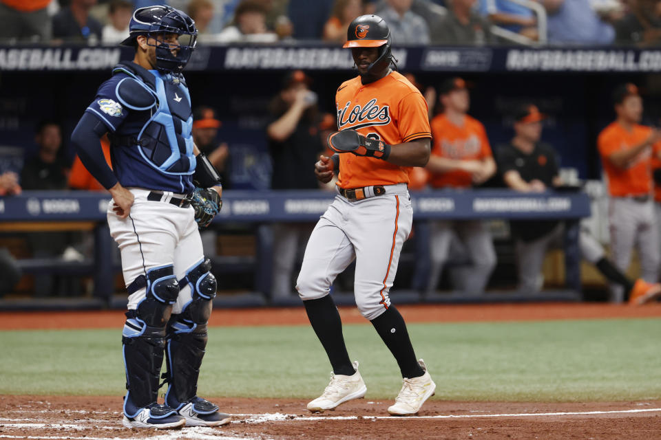 Baltimore Orioles' Jorge Mateo runs past Tampa Bay Rays' Rene Pinto to score during the fourth inning of a baseball game Saturday, July 22, 2023, in St. Petersburg, Fla. (AP Photo/Scott Audette)
