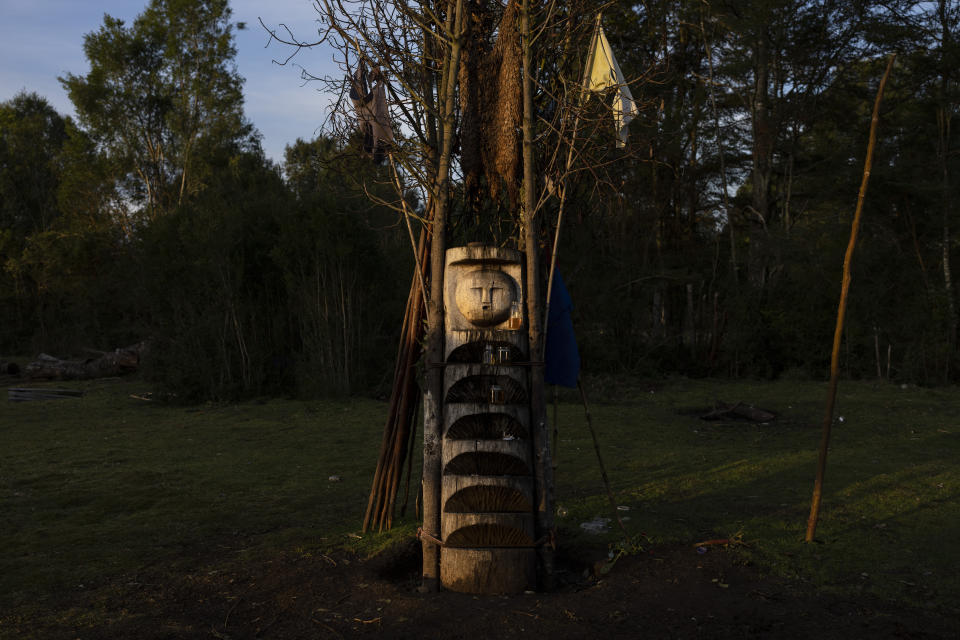 A rewue, or Mapuche ritual altar, is illuminated outside the home of Millaray Huichalaf, a machi, or healer and spiritual guide, in Carimallin, southern Chile, on Wednesday, June 22, 2022. For the Mapuche people, the rewue serves as a ladder to the spiritual world. (AP Photo/Rodrigo Abd)