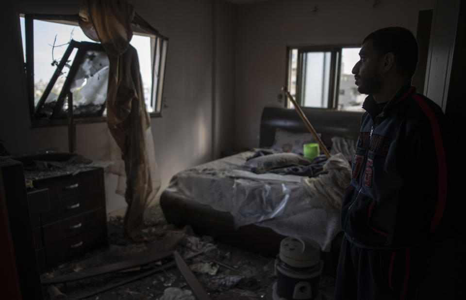 A Palestinian man looks at his damaged bedroom following early morning Israeli airstrikes on Gaza City, Tuesday, May 18, 2021. Israel carried out a wave of airstrikes on what it said were militant targets in Gaza, leveling a six-story building in downtown Gaza City, and Palestinian militants fired dozens of rockets into Israel early Tuesday, the latest in the fourth war between the two sides, now in its second week. (AP Photo/Khalil Hamra)