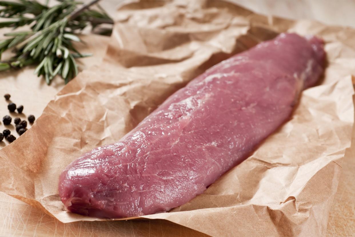 Raw pork tenderloin resting on brown butcher paper