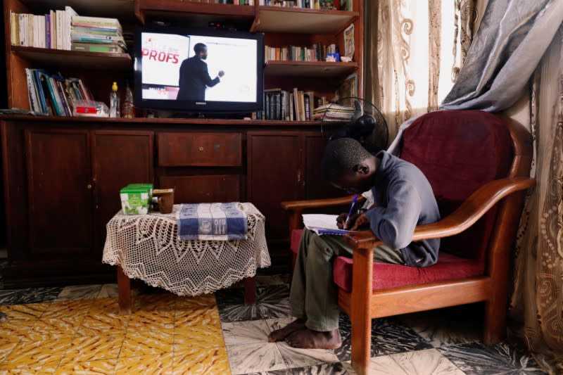 Ibrahima Diongue, 11, sits at home as he attends a math class broadcasting by a local TV channel, after the government ordered all educational establishments to close, one of the several new measures to control the spread of coronavirus disease in Dakar