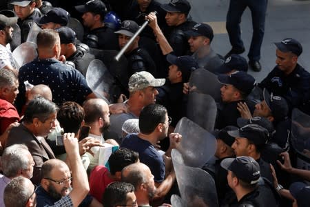 Police officers try to disperse demonstrators during a protest against a proposed new hydrocarbons law in Algiers