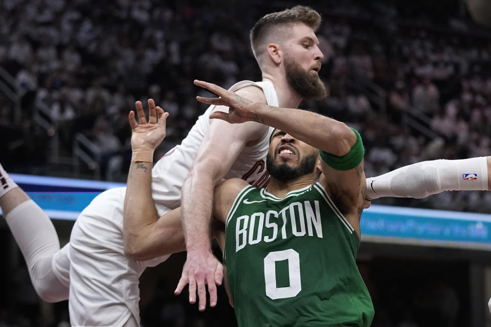 Boston Celtics forward Jayson Tatum (0) loses the ball after a foul by Cleveland Cavaliers forward Dean Wade, left, during the second half of Game 3 of an NBA basketball second-round playoff series Saturday, May 11, 2024, in Cleveland. (AP Photo/Sue Ogrocki)