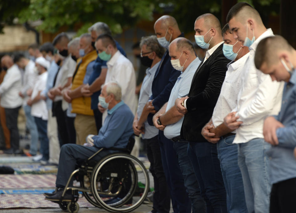 Worshippers wearing masks to help stop the spread of the coronavirus, offer Eid al-Adha prayer in front of the Gazi Husrev-beg mosque in Sarajevo, Bosnia, Friday, July 31, 2020. Eid al-Adha, or Feast of Sacrifice, Islam's most important holiday, marks the willingness of the Prophet Ibrahim to sacrifice his son. (AP Photo/Kemal Softic)