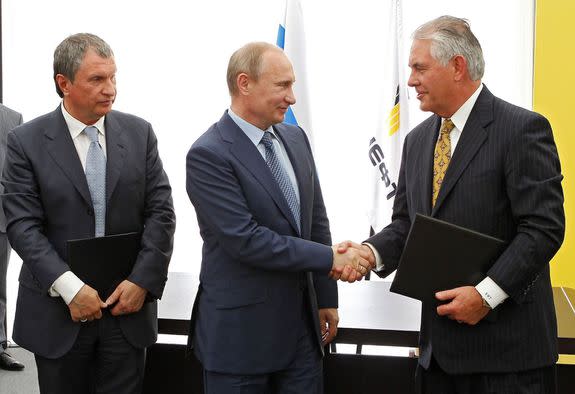 Russian President Vladimir Putin, center, and Exxon Mobil Corp. CEO Rex Tillerson shake hands on June 15, 2012.