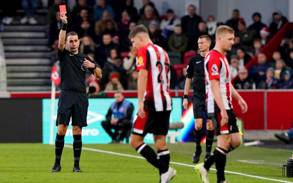 Referee David Coote shows a red card to Brentford's Ben Mee during a Premier League match at the Gtech Community Stadium in London.