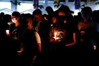 Students pay tribute with flowers to Chow Tsz-lok, 22, a university student who fell during protests at the weekend and died early on Friday morning, at the Hong Kong University of Science and Technology, in Hong Kong