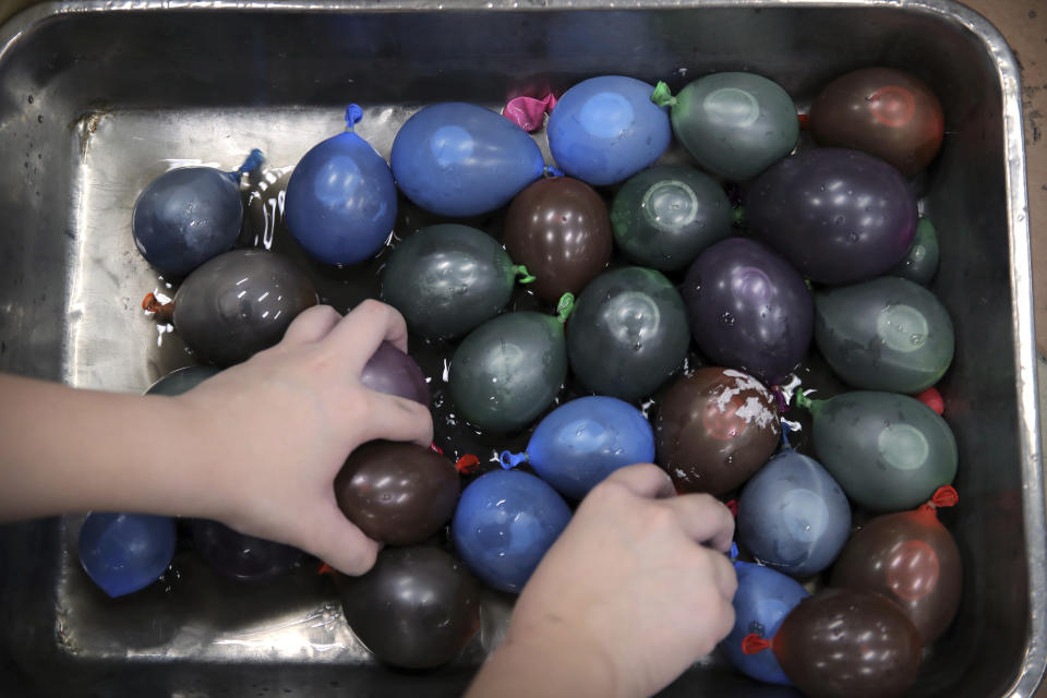 A protester fills balloons with paint and water at the Hong Kong Polytechnic University in Hong Kong, Friday, Nov. 15, 2019. Protesters who barricaded themselves inside Hong Kong’s universities have tried to turn the campuses into armed camps, resorting to medieval weapons to stop police from entering the grounds. Their weapons include bows and arrows, catapults and hundreds of gasoline bombs stacked up to ramparts - often built by the students. (AP Photo/Kin Cheung)