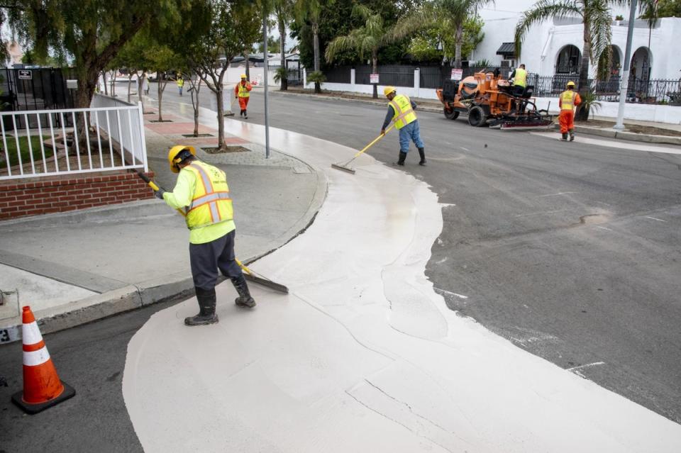 Workers put down a more reflective surface that can help cool down roads in Los Angeles (LA Bureau of Street Services)