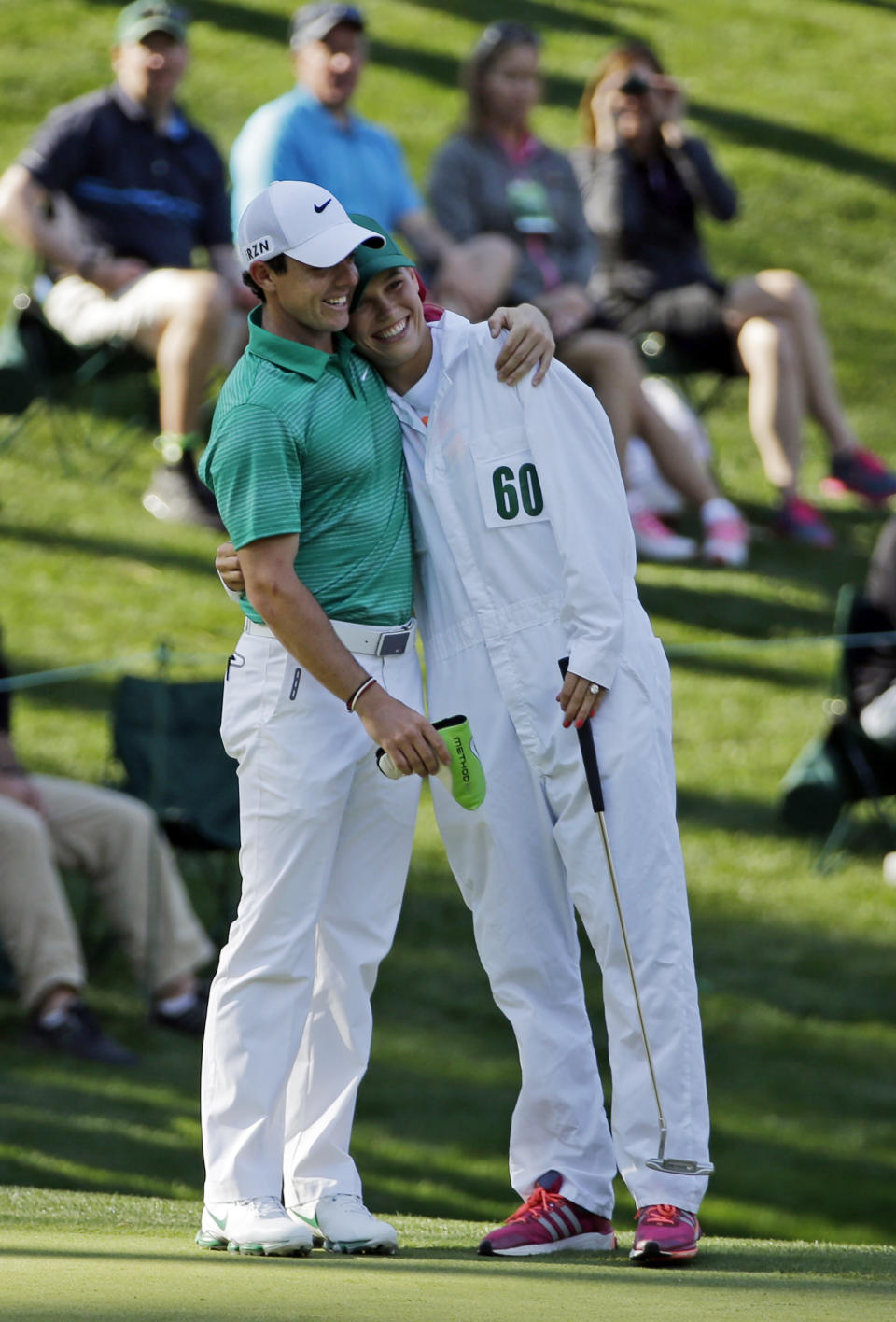 Rory McIlroy, of Northern Ireland, hugs tennis player Caroline Wozniacki after Wozniacki putted on the ninth hole during the par three competition at the Masters golf tournament Wednesday, April 9, 2014, in Augusta, Ga. (AP Photo/David J. Phillip)