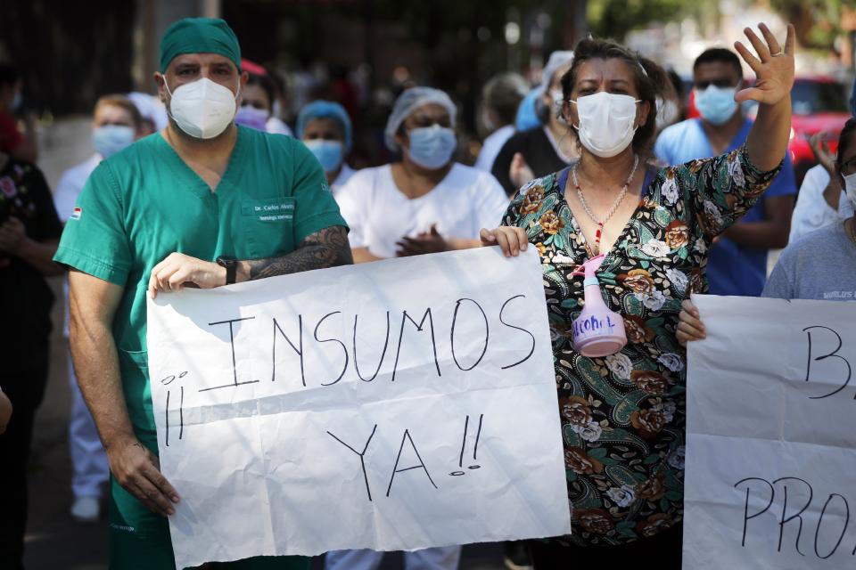 Respiratory Hospital INERAM health workers and families of patients there protest outside the hospital to demand more materials for the ICU in Asuncion, Paraguay, Wednesday, March 3, 2021, the day after INERAM Director Felipe Gonzalez resigned. The sign in Spanish says: "Supplies now!" Without vaccines or basic drugs to combat COVID-19, Paraguay's main public hospitals became unable to receive patients in intensive care units on Wednesday. (AP Photo/Jorge Saenz)