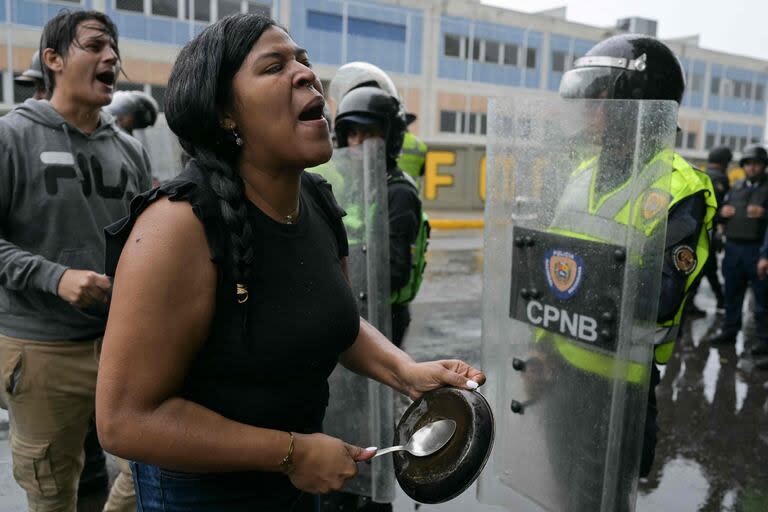 Opositores al gobierno del presidente venezolano Nicolás Maduro protestan frente a miembros de la Policía Nacional en el barrio de Catia.
