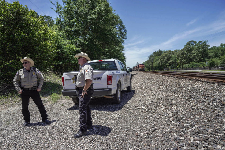 Authorities search near train tracks, in Cleveland, Texas, Monday, May 1, 2023, for a suspect who fatally shot five neighbors several days earlier. (Raquel Natalicchio/Houston Chronicle via AP)