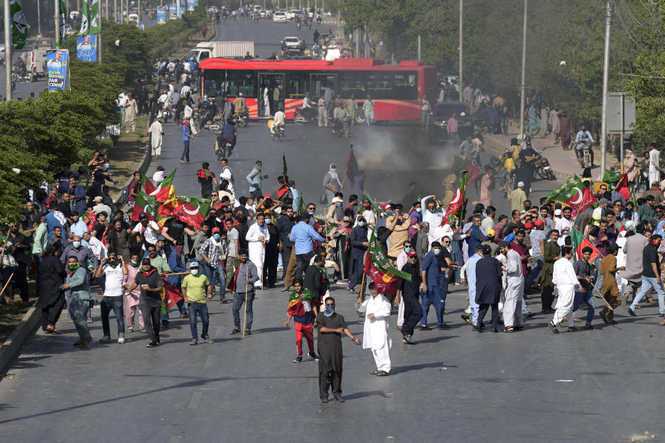 Supporters of Pakistan's former Prime Minister Imran Khan throw stones toward police during a protest against the arrest of Khan, in Karachi, Pakistan, Tuesday, May 9, 2023. Khan was arrested Tuesday as he appeared in a court in the country’s capital, Islamabad, to face charges in multiple graft cases. Security agents dragged Khan outside and shoved him into an armored car before whisking him away. (AP Photo/Fareed Khan)