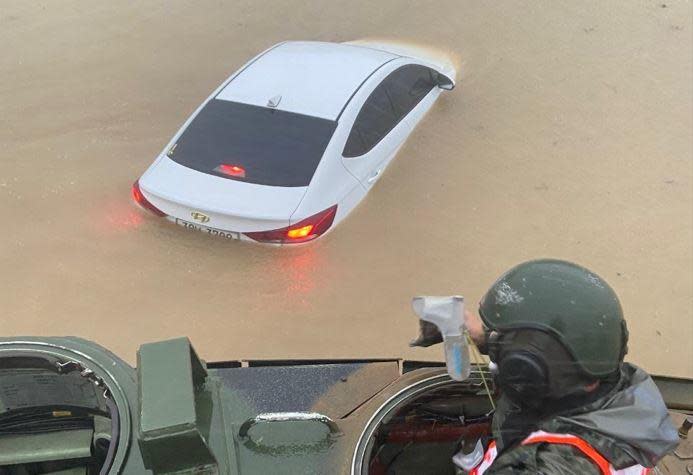 A Member of South Korea's Marine Corps 1st Division looks at a civilian vehicle submerged by floodwater in the southern city of Pohang, September 6, 2022, after Typhoon Hinnamnor brought huge rainfall to many southern parts of South Korea. / Credit: Republic of Korea Ministry of Defense/Handout
