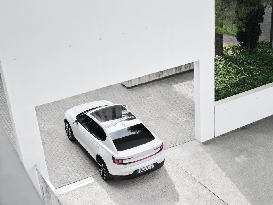 a white PS2 seen from above and to the left, sitting under a white arched wall  