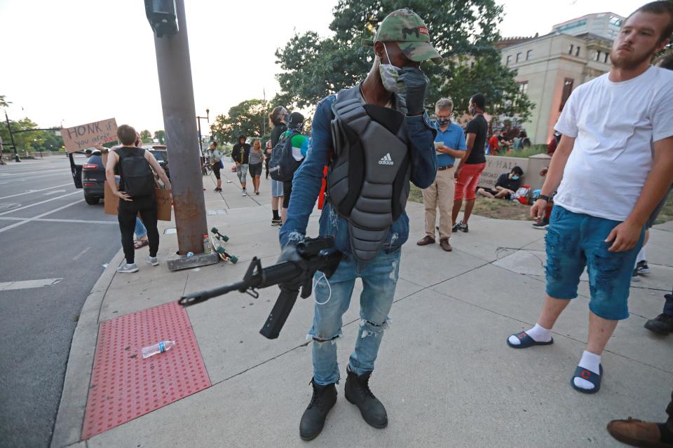 Jay Rocc holds a gun he says was an AR-15 in front of Columbus City Hall Wednesday, June 24, 2020 during the daily George Floyd protests in Columbus, Ohio.