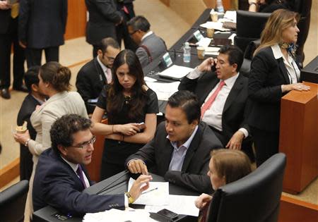 Senator Armando Rios Piter (L) of the Party of the Democratic Revolution (PRD) speaks with other senators, after fellow party members interrupted a debate on an energy reform bill at the Senate in Mexico City December 9, 2013. REUTERS/Henry Romero