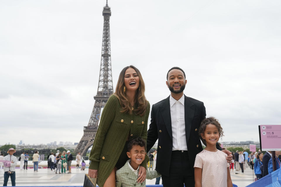 Chrissy Teigen y John Legend llegan con sus hijos, Miles, primer plano a la izquierda y Luna a París, Francia, antes de la ceremonia de apertura de los Juegos Olímpicos de Verano de 2024, el viernes 26 de julio de 2024. (Foto AP/Natacha Pisarenko)
