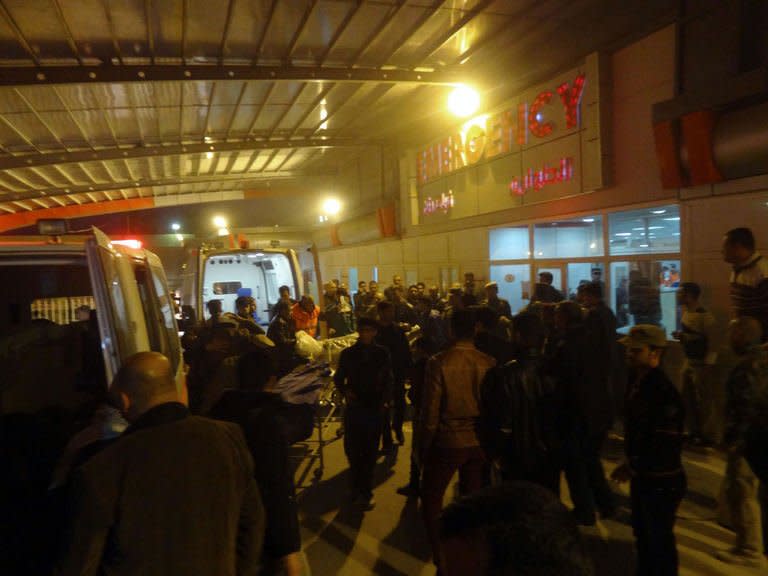 People gather around the entrance of a hospital in Kirkuk, north of Baghdad, on January 23, 2013, after a suicide bomber made his way into a Shiite mosque north of Baghdad and blew himself up in the middle of a funeral. He killed 42 people and left corpses scattered across the floor