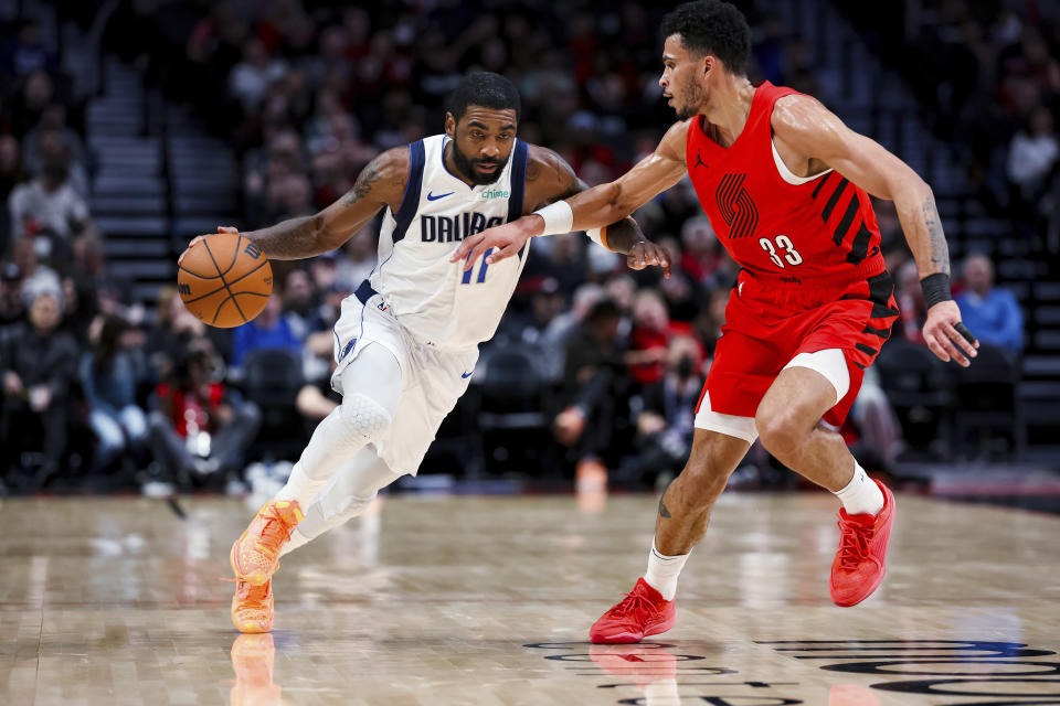 Dallas Mavericks guard Kyrie Irving drives against Portland Trail Blazers forward Toumani Camara during the first half of an NBA basketball game Friday, Dec. 8, 2023, in Portland, Ore. (AP Photo/Howard Lao)