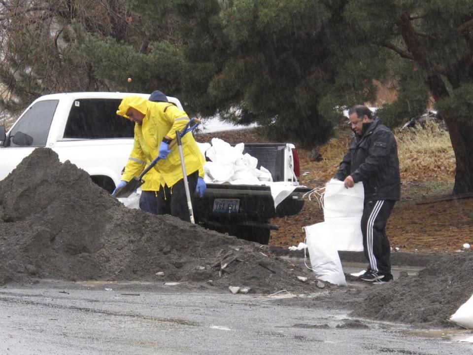 Local residents braved the heavy rain to fill sandbags on Sunday, Jan. 8, 2017, near the Truckee River in Sparks, Nev. More than 1,000 homes have been evacuated due to overflowing streams and drainage ditches in the area, which remains under a flood warning through Tuesday. (AP Photo/Scott Sonner)