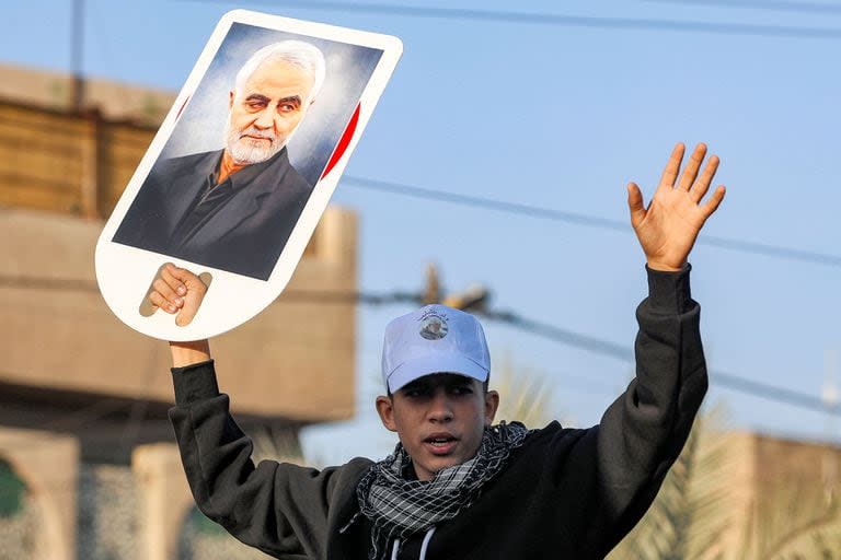 Un joven ondea un cartel con la imagen de Qassem Soleimani, el comandante fallecido de la Fuerza Quds del Cuerpo de la Guardia Revolucionaria Islámica de Irán (IRGC), quien fue asesinado por un ataque de dron estadounidense el 3 de enero de 2020. 