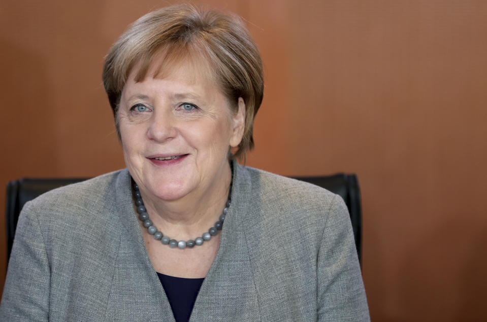 German Chancellor Angela Merkel smiles as she arrives for the weekly cabinet meeting at the Chancellery in Berlin, Germany, Wednesday, Dec. 18, 2019. (AP Photo/Michael Sohn)