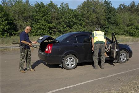 Pro-Russian activists check a car at a checkpoint outside the eastern Ukranian city of Luhansk May 21, 2014. REUTERS/Valentyn Ogirenko