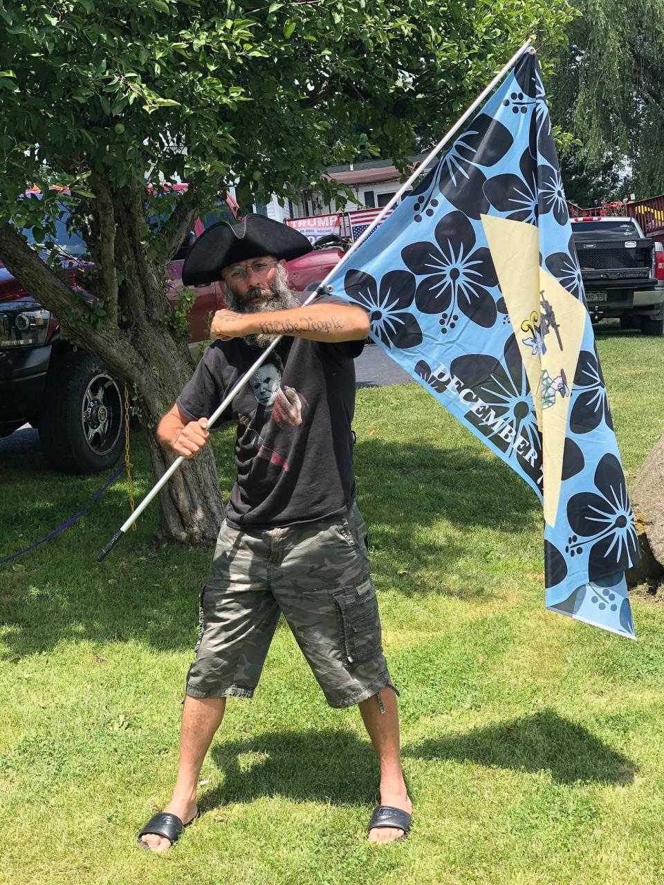 In this photo provided by the U.S. Attorney's Office, Delaware man Barry Croft is pictured in July 2020 carrying a "Boogaloo" flag in Cambria, Wisconsin.