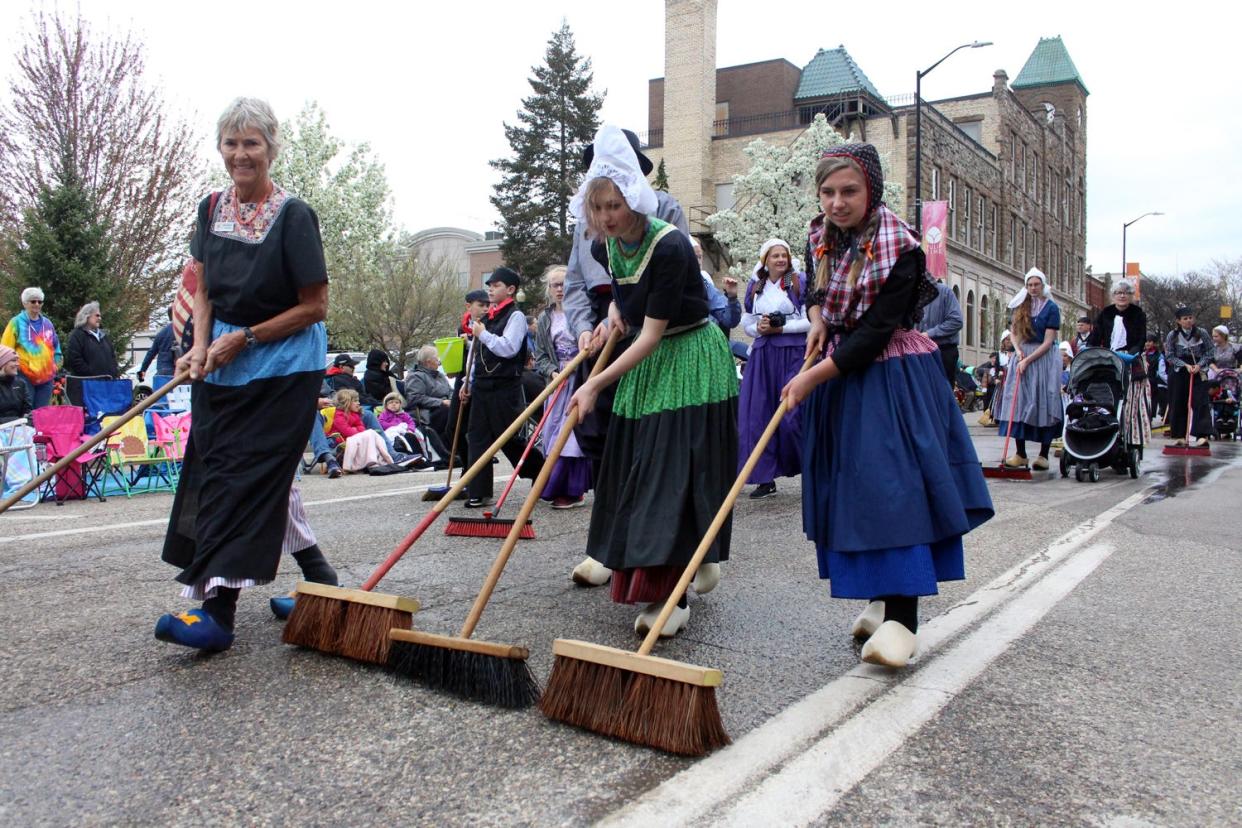 Holland residents "clean" the streets before the Tulip Time Festival Volksparade.