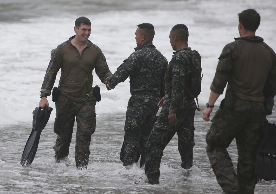 FILE - In this Sept. 20, 2013 file photo, a US Marine, left, from the 13th Marine Expeditionary Unit BOXER Amphibious Ready Group based in Okinawa, Japan, is greeted by Filipino Marines after jumping from a U.S. helicopter during a joint military exercise called Philippines-U.S. Amphibious Landing Exercise (PHIBLEX) in Ternate, Cavite province, southern Philippines. A new defense pact that will allow thousands of U.S. troops to be temporarily based in Philippines for the first time in more than 20 years signals closer cooperation in the allies’ hot-and-cold relationship that has been shaped over the decades by war, terrorism and now, jitters over China's rise. The 10-year agreement, signed Monday, April 28, 2014, as President Barack Obama arrived in Manila, was considered the centerpiece of his four-nation Asian trip, which he used to reassure allies like Japan and the Philippines of American military backing as they wrangle with China in increasingly tense territorial disputes. (AP Photo/Aaron Favila, File)