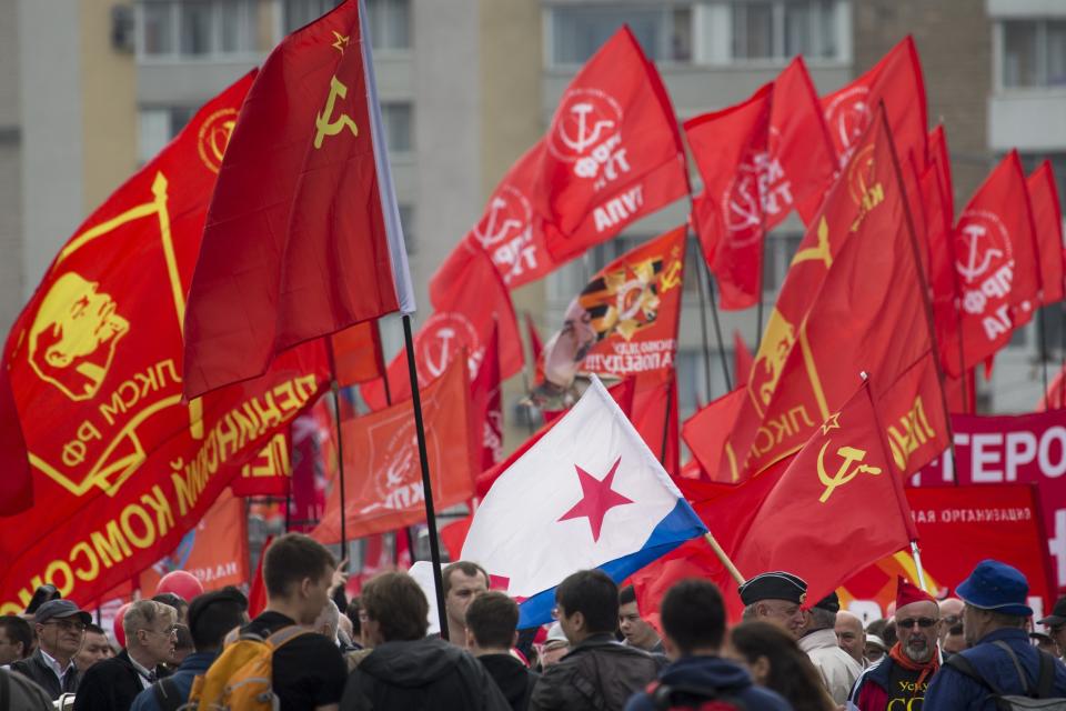 <p>People march with a former Soviet navy and red flags during a Communist rally to mark May Day in Moscow, Russia, May 1, 2018. More than 100,000 people came out on the streets on Moscow to march in the traditional May Day parade. (Photo: Alexander Zemlianichenko/AP) </p>