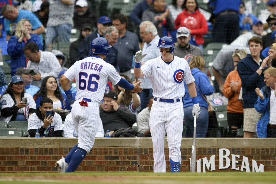 Chicago Cubs' Rafael Ortega (66) celebrates with teammate Frank Shwindel, right, after scoring on an error during the first inning of a baseball game against the Pittsburgh Pirates, Sunday, April 24, 2022, in Chicago. (AP Photo/Paul Beaty)