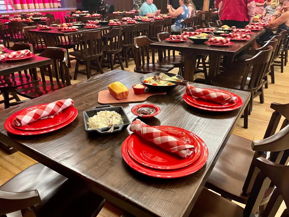 Hoop-De-Doo Revue at Disney wooden tables with red plates and plaid napkins on top