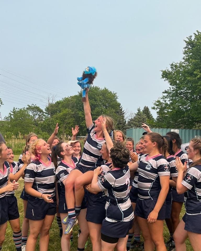 Corning captain Mykaela Reed gets a lift from teammates as she holds a blue Lion representing the team mascot following a 22-20 victory over Orchard Park in the RugbyNY state final June 4, 2023 at Tim Russert Park in Buffalo.