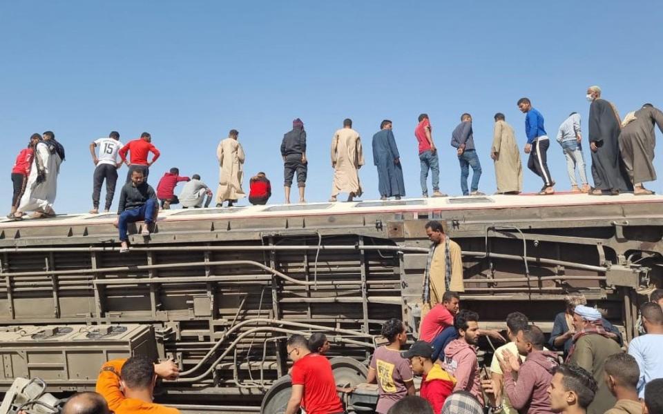 People gather to inspect damaged train cars after two passenger trains collided  - Mahmoud Maqboul/Cover Images 