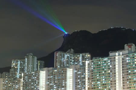 Anti-extradition bill protesters use laser beams as they form a human chain on top of the iconic Lion Rock, at Wong Tai Sin, during mid-autumn festival in Hong Kong