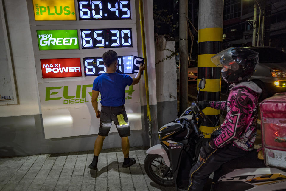 MANILA, PHILIPPINES - MARCH 07: A worker adjusts the prices of fuel on a display as motorists queue at a gas station a day before a huge price increase on petroleum products is implemented, on March 07, 2022 in Quezon City, Metro Manila, Philippines. Shares in Asian markets declined on Monday amid fears of an inflation shock in the world economy already reeling from pandemic-era snarls as the ongoing Russia-Ukraine war continues to send oil prices soaring. (Photo by Ezra Acayan/Getty Images)