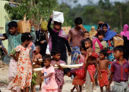 Rohingya refugees who are affected by Cyclone Mora, come back to their makeshift home after collecting relief supplies at the Balukhali Makeshift Refugee Camp in Cox’s Bazar, Bangladesh May 31, 2017. REUTERS/Mohammad Ponir Hossain