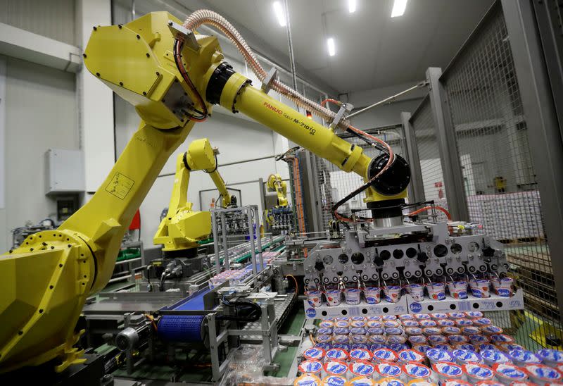 Robotic arms sort and load yogurts onto pallets at a distribution centre near Prague