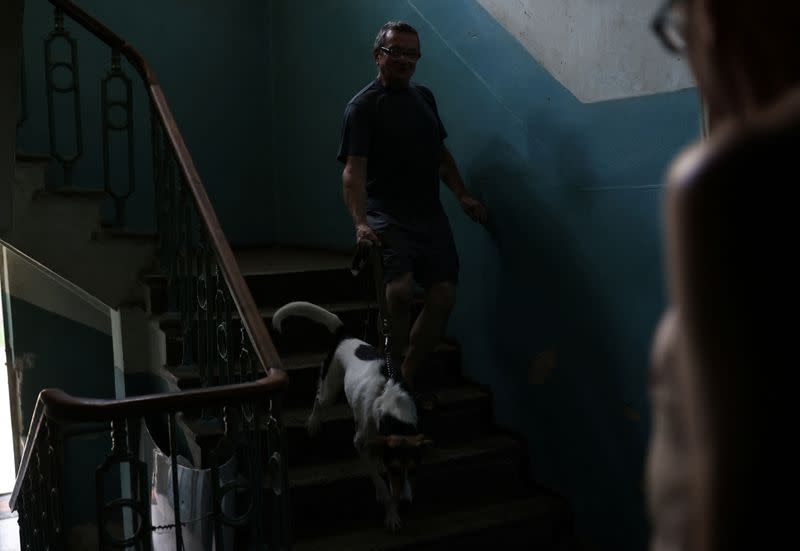 Vicktor, un discapacitado visual, baja las escaleras acompañado de su perro en un albergue para ciegos, en medio de la invasión rusa de Ucrania, en Jarkov