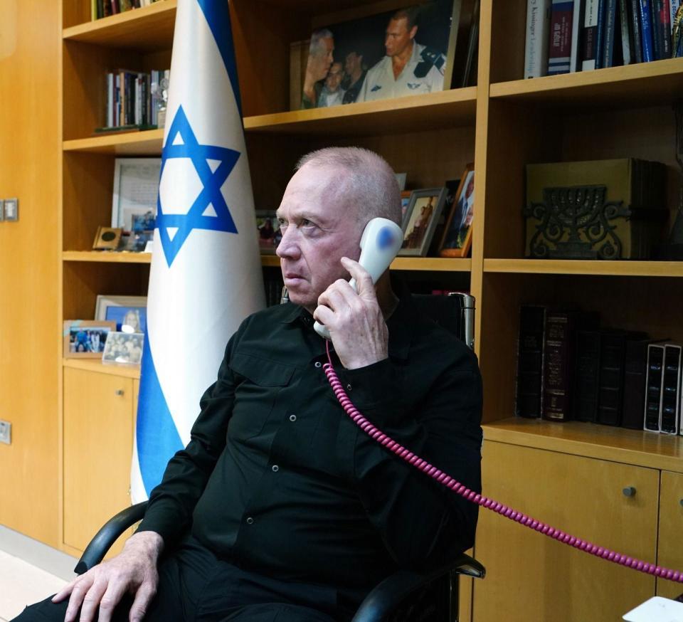 Israeli Defence Minister Yoav Gallant holds a telephone to his ear in this photo released by the Israeli Ministry of Defence (Israeli Ministry of Defence / Ariel Hermoni)