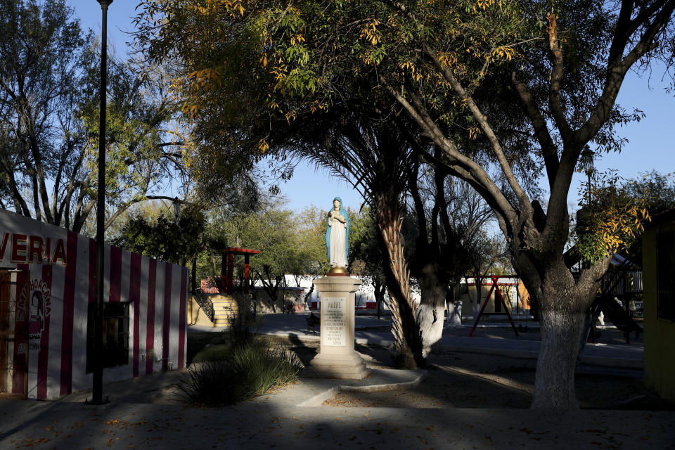 A pocket of light illuminates a statue of the Virgin Mary in Villa Union, Mexico, Monday, Dec. 2, 2019. The small town near the U.S.-Mexico border began cleaning up Monday even as fear persisted after 22 people were killed in a weekend gun battle between a heavily armed drug cartel assault group and security forces. (AP Photo/Eduardo Verdugo)