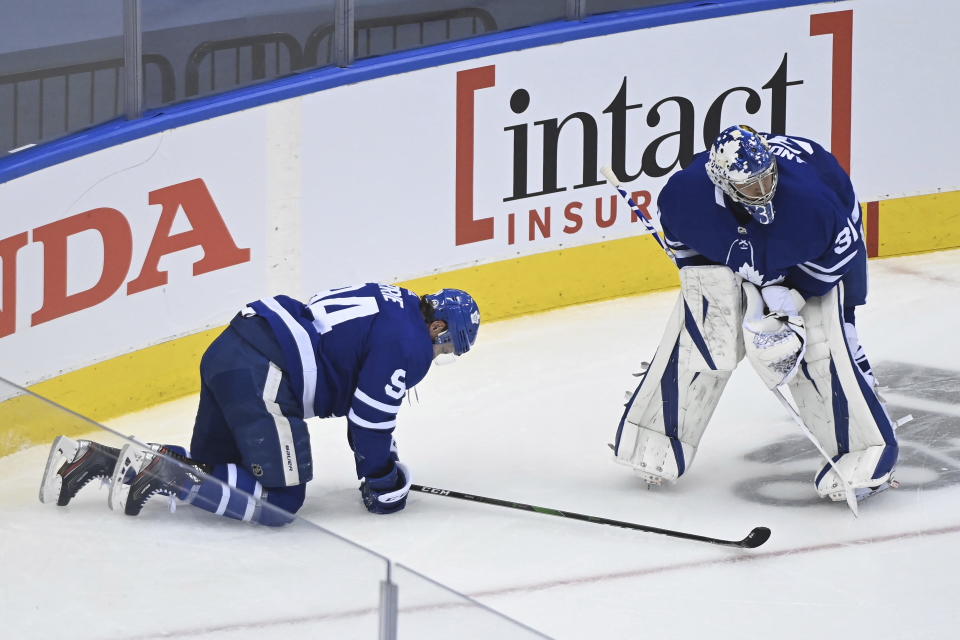 Toronto Maple Leafs defenceman Tyson Barrie (94) is slow to get up off the ice as Leafs goaltender Frederik Andersen (31) looks during the second period of an NHL Eastern Conference Stanley Cup playoff game in Toronto on Sunday, Aug. 9, 2020. (Nathan Denette/The Canadian Press via AP)