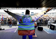 A speaker gestures to the crowd during a demonstration against COVID-19 measures in Brussels, Sunday, Jan. 23, 2022. Demonstrators gathered in the Belgian capital to protest what they regard as overly extreme measures by the government to fight the COVID-19 pandemic, including a vaccine pass regulating access to certain places and activities and possible compulsory vaccines. Sign at center left and right reads 'No to obligatory vaccines'. (AP Photo/Olivier Matthys)